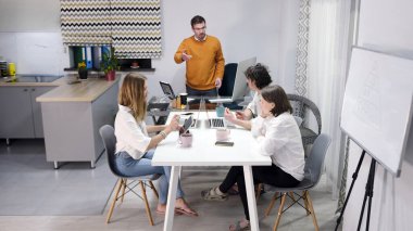 Şirket başkanı planı yerine getirmediği için çalışanlarını sayıyor. Bir grup insan toplantı odasında dizüstü bilgisayarlarla bir masada oturuyor. Sahne odaklandı.