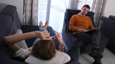 Bir psikoloğun yardımı. Ciddi, kendinden emin bir adam mavi koltukta oturur ve hastasını dikkatle dinler. Psikanalist servisleri. İletişim ve bakım