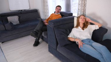 Yakışıklı bir psikolog hastasına yönlendirici sorular sorar. Bir kadın sinir krizi geçirir. Psikanalist elinde bir tablet tutuyor ve kadın mavi bir kanepede uzanıyor ve rahatlamaya çalışıyor..