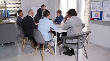 Bir iş şirketinin mutlu çalışanları konferans odasında beyaz bir masada oturuyorlar. Sahne profesyonelce, çünkü insanlar tartışmanın içinde. Önemli bir anlaşmayı tartışıyoruz.