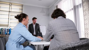 Toplantı yöneticileri konferans odasında. Bir adam beyaz bir tahtanın önünde duruyor ve bir sunuma öncülük ediyor. İş konsepti. Sabah toplantısındaki meslektaşlar.