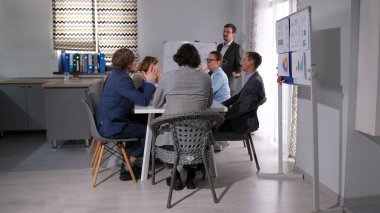 Bir grup avukat konferans odasında bir masada oturmuş yeni bir müşterinin savunmasını tartışıyorlar. Profesyonel bir psikolog bir iş şirketinde eğitim verir..