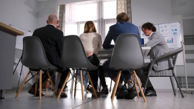 Birkaç iş adamı konferans odasındaki bir masada oturuyorlar. Girişimciler büyük bir iş projesinde birlikte çalışıyorlar. Personel verimliliğini arttır