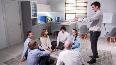 Çalışma verimliliğini arttırıyorum. Takımdaki atmosferi geliştiriyorum. Çalışanların motivasyonunun artması. Liderlik gelişimi. Güven ve karşılıklı anlayışı arttır. Bir grup insan bir odada yerde oturuyor.,