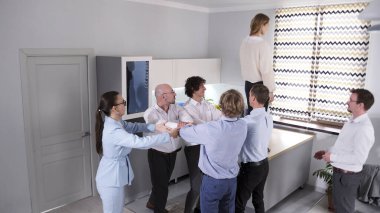 Bir çalışan ya da iş arkadaşı için güven oyunu kavramı. Takım oluşturma etkinliği serbest düşüş. Bir meslektaşıma destek oluyorum. Bir grup işadamı, kadın düşerken onu yakalamak için platformda duran bir kadının önünde sıraya girdiler..