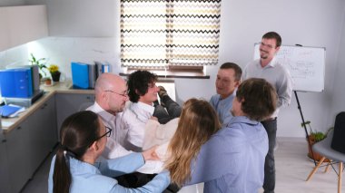 Mutlu meslektaşlar meslektaşlarını Serbest Düşüş oyununda yakaladıkları için mutlular. Takım oluşturma ofis oyunları. Güven ve destek. Sahne kaygısız ve eğlenceli, grup hayattan zevk alıyor ve eğlenceli şeyler yapıyor..