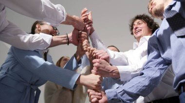 Genç pazarlama profesyonelleri eğlenceli bir liderlik geliştirme oyunu oynuyorlar. Bir grup insan bir çemberin içinde, elleriyle yüksek bir kule inşa ediyorlar. Sahne olumlu ve dostane.