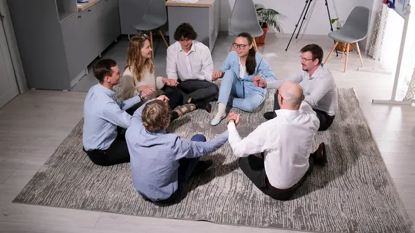 Bir grup başarılı girişimci aile ofisindeki bir paspasın üzerinde el ele tutuşuyorlar. Karşılıklı destek ve saygı. Öğretim üyesinden danışma