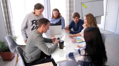 Yaratıcı bir grup öğrenci pazarlama alanında büyük bir ortak proje üzerinde çalışıyor. Olay yeri dinlenme yeri. Genç uzmanlar tasarım haberlerini tartıştılar