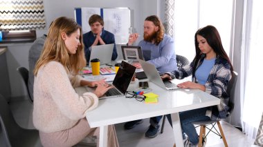 Şirketin yöneticileri bir konferans odasında bir proje üzerinde çalışıyorlar. Bir grup insan dizüstü bilgisayarları açık bir masada oturuyor. İş ofisi. Takım çalışması.