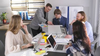 Satış müdürü bir toplantıda patronla konuşuyor. Bir grup insan aile ofisindeki bir masada oturuyor ve yeni bir proje üzerinde çalışıyorlar. İşbirliği atmosferi