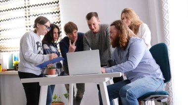 Kızıl saçlı, kıvırcık saçlı, sakallı bölüm başkanı beyin fırtınası için meslektaşlarını topladı. Takım çalışması. Bir grup insan bir şey tartışıyor..