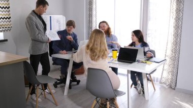 Yönetim kurulu yeni iş geliştirme stratejisi hakkında şüpheci. Bir grup insan konferans odasında bir masada oturuyor ve astları olma fikriyle alay ediyorlar.