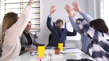Takım çalışması. Şirketin doğum gününü kutlama konsepti. Bir grup insan mutluluk ve sevinçle ellerini havaya kaldırıyor. Takım oluşturma. İş Ofisi