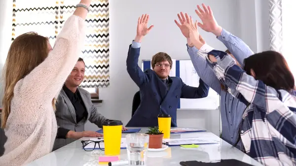 Takım çalışması. Şirketin doğum gününü kutlama konsepti. Bir grup insan mutluluk ve sevinçle ellerini havaya kaldırıyor. Takım oluşturma. İş Ofisi
