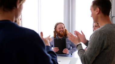 Şirket personeli başarılı patronlarını alkışlıyor. Büyük bir alışverişin tamamlanması. Bir meslektaşımın doğum gününü kutluyorum. Bir grup insan ellerini çırpıyor ve birbirlerine gülümsüyor..