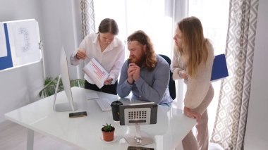 Genç bir iş adamı ekibi satışların büyümesi ve düşüşünü analiz ediyor. Müdürün ofisinde üç kişi toplantı yapıyor. Meslektaşlar bir iş sunumunu inceliyor