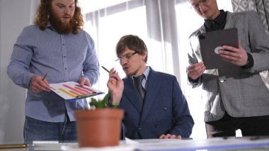 Yakışıklı, şık bir adam, bir iş şirketinin başı, astlarına talimatlar verir. Sahne profesyonel ve odaklanmış. Aile ofisi. Girişimcinin çalışma günleri