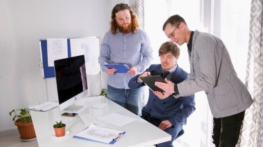 Kişisel asistan imzası için tablet üzerindeki sözleşmeyi patrona gösterir. Ve şirketin müdürü onay için belgeleri getirdi. İş ofisi. Sahne profesyonel ve odaklı.