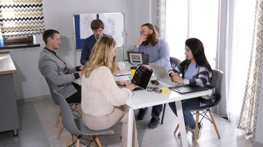Uykulu bir satış müdürü konferans odasında bir brifingde uyuyakalır. Şirketin çalışanları dizüstü bilgisayar ve kağıtlarla dolu bir masada oturuyorlar..