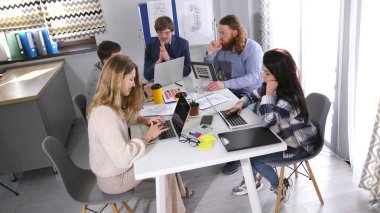 Bir reklam şirketinin ofisinde verimli bir gün geçir. Bir grup yaratıcı genç insan bir masada oturuyor ve bir proje üzerinde çalışıyorlar. Sahne odaklandı.