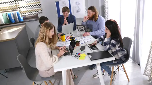 Bir reklam şirketinin ofisinde verimli bir gün geçir. Bir grup yaratıcı genç insan bir masada oturuyor ve bir proje üzerinde çalışıyorlar. Sahne odaklandı.