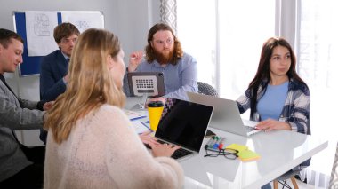 Bir grup insan dizüstü bilgisayarlarla bir masada oturuyor ve yeni bir reklam projesi üzerinde çalışıyorlar. Bir reklam ajansının çalışma günleri. Tasarım Bürosu