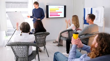 Seyirci genç öğretim üyesini alkışlıyor. Profesyonel bir akıl hocası iş eğitimi verir. Bir grup insan meslektaşlarının sunumunu izliyor..