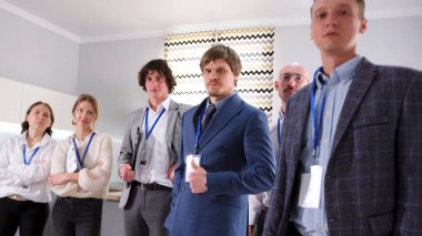 Takım elbiseli ciddi bir avukat grubu konferans odasında duruyor. Şirketin lideri bunu onaylıyor. Başarılı bir danışmanlık firması. İş eğitimi