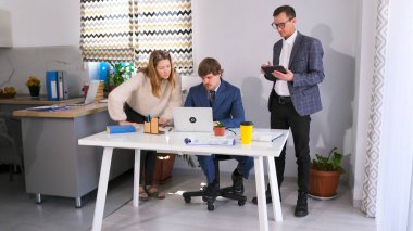 Yaratıcı öğrenciler bir girişim başlattılar. Üç kişi bir dizüstü bilgisayarla bir masada toplandı ve dikkatlice ekrana baktı. Takım çalışması ve beyin fırtınası..