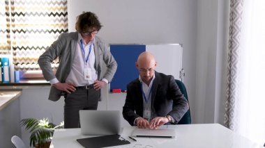 Genç, yakışıklı bir stajyer müdürün masasında görev için bekliyor. İki iş adamı bir aile ofisinin konferans salonunda çalışıyor. Öğrenci ve öğretmen