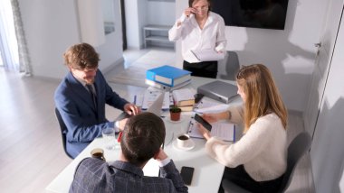 Bir grup genç girişimci konferans odasında bir masada oturuyorlar. Avukatlar ve ekonomistler ortak bir proje üzerinde çalışıyorlar. Takım çalışması.