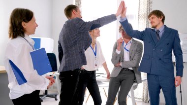 Başarılı takım çalışması kavramı. Takım oluşturma ve çalışan birliği. Bir grup insan birbirine beşlik çakıyor. Atmosfer profesyonel ve dost canlısı.