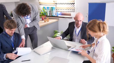 Bir grup iş adamı laptoplar ve kağıtlarla dolu bir masada çalışıyor. Şirketin avukatları, ekonomistleri ve analistleri önemli bir projeyi tartışıyorlar. Takım çalışması. Beyin fırtınası oturumu.