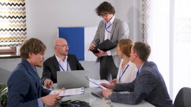 Yakışıklı genç bir avukat konferans odasında meslektaşlarına danışmanlık yapıyor. Birkaç iş adamı bir dizüstü bilgisayar ve kağıtlarla bir masada oturuyorlar. Şirket yöneticilerinin toplantısında sabah planlama oturumu.