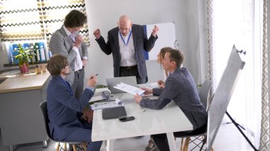 Patronun hoşnutsuzluğu. Patron astlarının çalışmalarına çok kızmış durumda. Çalışanların işten çıkarılması. Bir grup analist konferans odasında bir masada oturmuş bir proje üzerinde tartışıyorlar..