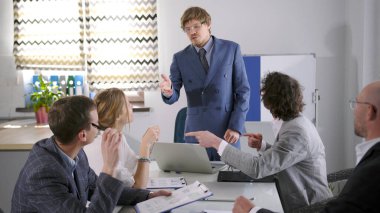 Şirketin mavi takım elbiseli başkanı ofiste brifing veriyor. Bir grup insan konferans odasında bir masada oturuyor ve yeni bir girişimi tartışıyorlar. Yöneticiler toplantısında sabah planlama oturumu