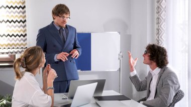 İş adamları bir iş ortamında masada tartışıyorlar. Gözlüklü ve mavi takımlı bir adam meslektaşının argümanlarını dinler. Proje detaylarını tartışacağız. Sabah müdürleri toplantısı..