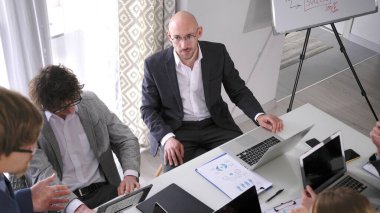 Brifing. Takım elbiseli bir adam iş eğitiminde bir grup işadamıyla aynı masada oturuyor. Akıl hocasına bakıyor ve profesyonel bir ortamda. Şirketin kurucularıyla toplantı.