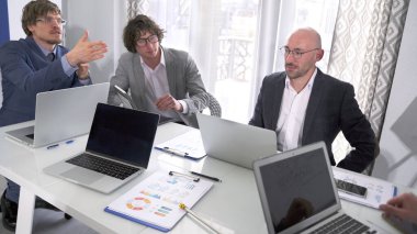 Brifing. Şirketin birkaç büyük departman başkanı bir toplantıda. Bir grup adam dizüstü bilgisayar ve kağıtlarla dolu bir masada oturuyor. Önemli bir projeyi tartışıyorlar. Sabah planlama oturumu