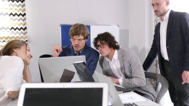 Proje detaylarını tartışacağız. Sabah planlama seansı. Bir grup acemi dizüstü bilgisayarları açık bir masada oturuyor. Hepsi işine odaklanmış ve bu konuda ciddi..