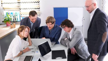 Ekonomistler ve finansörlerden oluşan bir ekip iş başında. Bir grup girişimci erkek ve bir kadın dizüstü bilgisayar ve kağıtlarla bir masada oturuyorlar. Şirketin yeniden yapılandırılması hakkında konuşuyorlar.