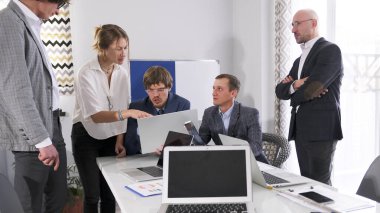 Yönetim kurulu bir iş projesini dizüstü bilgisayarda tartışıyor. Girişimcilerden oluşan bir ekip konferans odasındaki masanın etrafında toplandı. Bir danışmanlık şirketinin çalışma günleri..