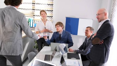 Profesyonel ve iş birliği sahnesi. Bir grup erkek ve bir kadın sekreter önemli bir işlemin detaylarını konferans odasında tartışırlar. Sabah planlama oturumu