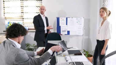 Başarılı bir profesyonel akıl hocası ve asistanı iş eğitimi üzerine bir sunum yapıyor. Brifingde takım çalışması. Sabah planlama seansı. Çalışma anları