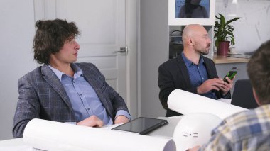 İki işadamı yönetim kurulunda mimardır. Mühendisler yeni bir tesisin inşasının detaylarını tartışıyorlar. Yönetmenler toplantısı. Planlama toplantısı. Kurucular Toplantısı