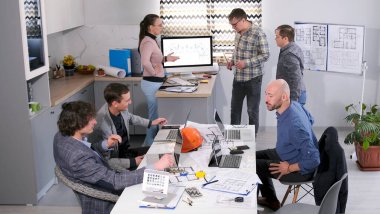 Bir grup mühendis, inşaatçı, tasarımcı ve mimar yeni bir proje üzerinde çalışıyor. Takım çalışması, takım oluşturma ve beyin fırtınası. İşbirliği ve konsantrasyon atmosferi