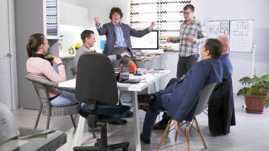 İnşaat şirketinin çalışanları ihaledeki zaferi kutluyor. Bir grup insan toplantı odasındaki mutfak masasının etrafında toplandı ve mimari nesnenin detaylarını konuşuyorlar..