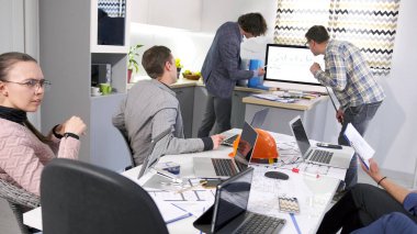 Yeni bir modern iş merkezinin inşasının aşamalarını tartışma süreci. Bir grup insan bir aile ofisinin konferans odasında çalışıyor. Masada birkaç dizüstü bilgisayar var.