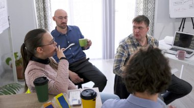 Kahve molası. Bir grup insan bir fincan kahve ve bir dizüstü bilgisayarla bir masada oturuyor. İş yemeği. Şirket genel konular hakkında konuşur. Meslektaşlar konferans odasında oturuyorlar.